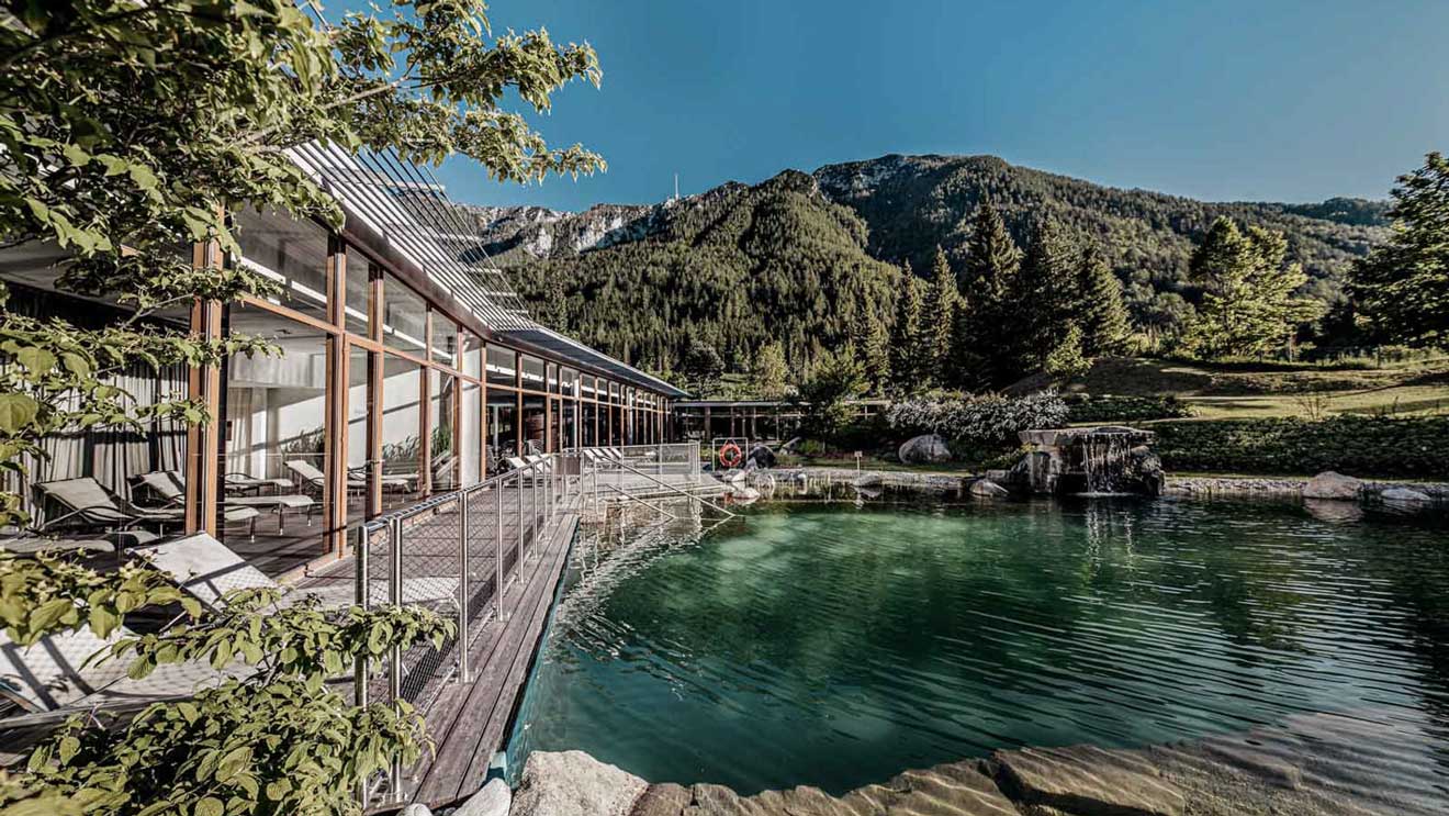 Entspannen im Naturbadeteich: Das BLEIB BERG F.X. Mayr Retreat verfolgt einen ganzheitlichen Ansatz für nachhaltiges Wohlbefinden.